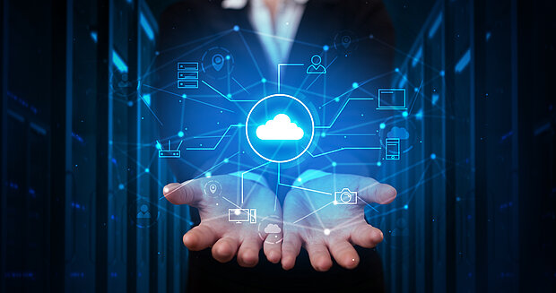 Über einer Hand schweben transparente Darstellungen von Cloud-Dienstleistungen
